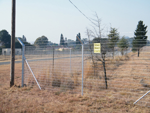 Welded mesh fencing with barbed wire overhang